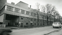 Moss Glasværk med hovedinngangen i Helgerødgata på Jeløy og den kjente glassverk-klokka på taket. Bildet er fra 1991. Moss Dagblads arkiv / Moss by- og industrimuseum / Fotograf ukjent